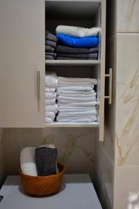 a closet with towels and a basket of towels at Dolphins House in Lixouri