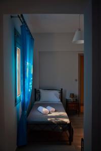 a bedroom with a bed with blue drapes at Dolphins House in Lixouri