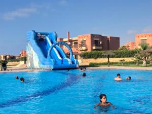 - un groupe de personnes dans une piscine avec toboggan dans l'établissement شاليه جديد عائلي كبير, à Dawwār al Ḩajj Aḩmad
