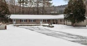 a house with a snow covered roof in the snow at Mountainscape Cabins 1 in Thornton