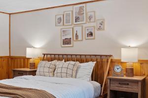 a bedroom with a bed with two nightstands and pictures on the wall at Mountainscape Cabins 1 in Thornton
