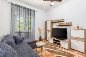 a living room with a blue couch and a tv at Apartman Mia in Pula