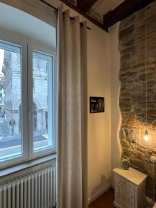 a room with a large window with a stone wall at Santorio 5 Apartment in Trieste