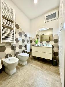 ein Badezimmer mit einem WC, einem Waschbecken und einem Spiegel in der Unterkunft Tribunali 181 Guest House in Neapel