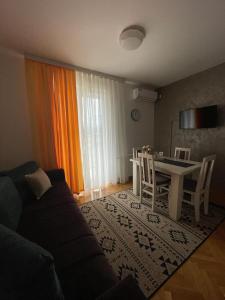 - un salon avec un canapé et une table dans l'établissement Apartman MINIKI, à Vrnjačka Banja