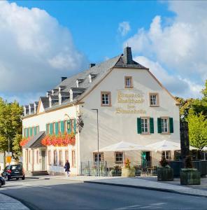 un gran edificio blanco al lado de una calle en Zum Simonbräu en Bitburg