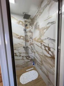 a bathroom with a shower with a marble wall at Jupis Chalet-City View Getaway in Durrës +32 photos