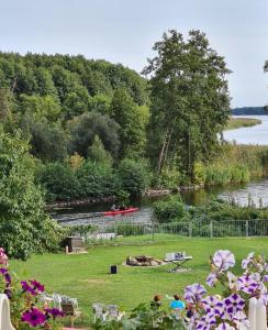 a view of a river with people sitting on a bench at Ferienbungalows am See in Altfriesack