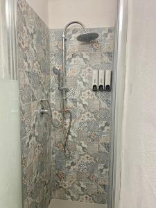 a shower in a bathroom with a mosaic wall at Ortigia Dreaming in Siracusa