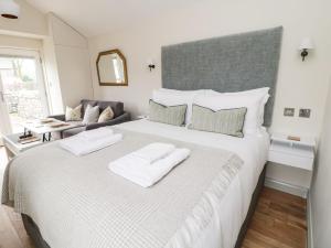 a bedroom with a large bed with two white towels at The Folly in Skipton