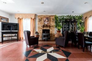 a living room with black chairs and a fireplace at Star's House Sevilla.Con piscina,10 min de Sevilla in Valencina de la Concepción