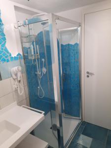 托雷戴科爾薩里的住宿－Villa la Torre Libeccio，浴室设有蓝色瓷砖淋浴。