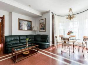 a living room with a green couch and a table at Star's House Sevilla.Con piscina,10 min de Sevilla in Valencina de la Concepción