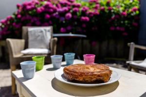 ciasto na talerzu na stole z kwiatami w obiekcie Petite maison bourg de La Trinite sur Mer - 4 à 6 couchages w mieście Trinité-sur-Mer +15 zdjęć