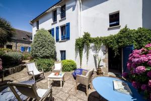 patio z krzesłami i stołem przed budynkiem w obiekcie Petite maison bourg de La Trinite sur Mer - 4 à 6 couchages w mieście Trinité-sur-Mer