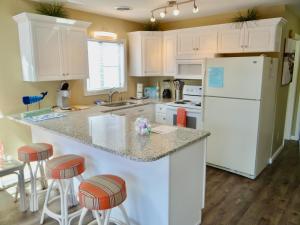 cocina con armarios blancos y nevera blanca en Coral Cottage-3B GCR en Myrtle Beach