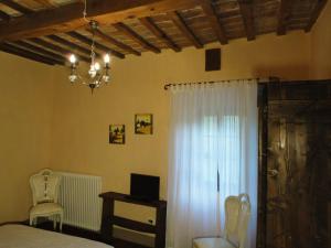 a bedroom with a bed and a window and a chandelier at Casa Shalom in Pennabilli