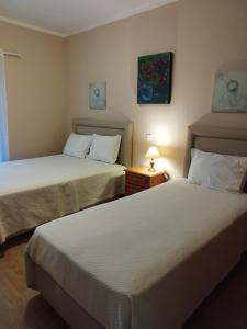 a bedroom with two beds and a lamp on a table at Sunshine in Albufeira