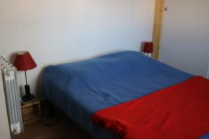 a bedroom with a blue and red bed and a lamp at La Villa K NARD au centre de Saint Trojan in Saint-Trojan-les-Bains