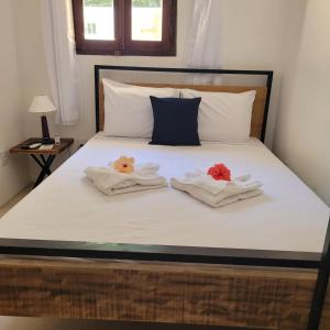 a bedroom with a bed with towels on it at Apartamentos Terra Mar in Trancoso