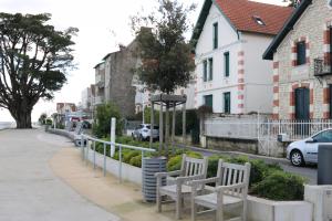 a row of white benches sitting on a sidewalk at La Villa K NARD au centre de Saint Trojan in Saint-Trojan-les-Bains
