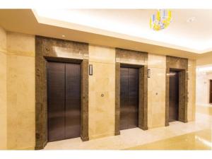 une rangée de trois portes d'ascenseur dans un bâtiment dans l'établissement HOTEL LANTANA Naha Kokusai Street - Vacation STAY 65442v, à Naha