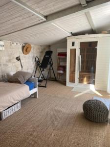 a bedroom with a bed and a chair in a room at Le Chai Maison de charme pour tribu joyeuse in Grand-Village-Plage