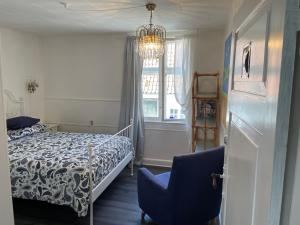 1 Schlafzimmer mit einem Bett, einem Fenster und 2 Stühlen in der Unterkunft Badehotel Harmonien in Ærøskøbing