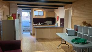 a kitchen with a refrigerator and a table in it at Pemberton Hostel - note - Go to Gloucester Motel Reception for check in - Backpackers 88 days farm work available in the Manjimup and Pemberton Region in Pemberton