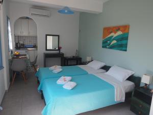 a bedroom with two beds with towels on them at Asterias Mini Coastal Apartments in Perivolos