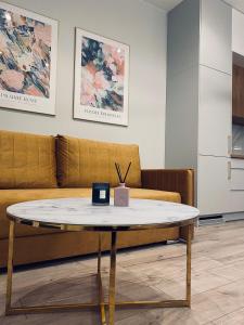 a coffee table in a living room with a couch at Golden Apartment Lodz, Zdrowie in Łódź