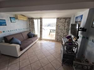 a living room with a couch and a sliding glass door at Appartamento La Terrazza al Gallo di Gallura in Santa Teresa Gallura