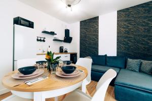 a dining room with a table and a blue couch at Apartament Marbud 2 przy Aquaparku Reda in Rumia