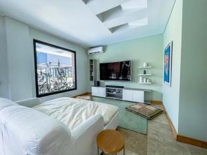 een slaapkamer met een wit bed en een televisie bij Casa Quinta de Lujo Villeta MyS in Villeta