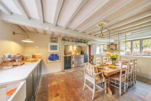 a kitchen with a wooden table and chairs in a room at Ford Cottage in Corscombe