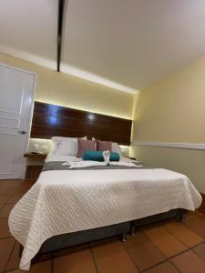 a bedroom with a large bed with a wooden headboard at HOTEL CAMPESTRE MANOA in Rivera