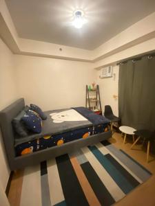 a small bedroom with a bed and a rug at 1 BR Condo Unit at The Celandine Condominium near Ayala Cloverleaf Mall in Manila