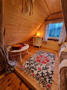 um quarto com uma cama e um tapete numa cabina em Wiejska Chata em Barczewo