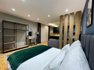 a bedroom with a large white bed and a desk at Premium Apartments in Gjakove
