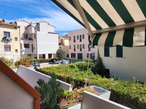 a balcony with a green and white umbrella and buildings at Solaris18 in Marina di Campo