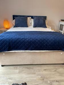 1 dormitorio con 1 cama con edredón azul en The Stable Yard @ Manor Bank Cottage en Beaulieu