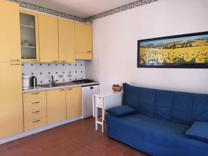 a living room with a blue couch and a kitchen at Solaris18 in Marina di Campo