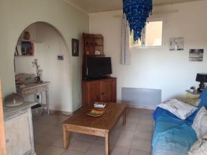 een woonkamer met een tafel, een bank en een tv bij Petite maison bord et vue mer, 55 m2 in Martigues