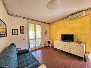 a living room with a couch and a tv at Solaris18 in Marina di Campo