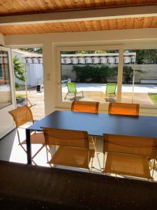 una mesa azul y sillas en una habitación en La Taniere, piscine et 300m de la mer, en Saint-Georges-dʼOléron