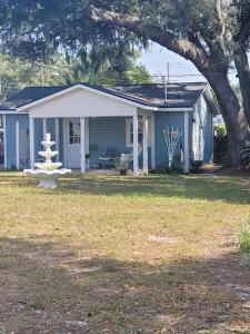 a small blue house with a fountain in the yard at Historic GWALTNEY HOUSE-Cottage at St Andrew's Bay in Panama City