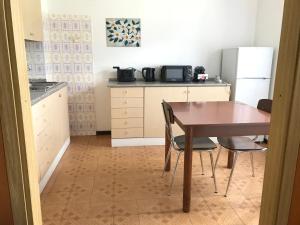 a kitchen with a table and chairs and a refrigerator at Casa Silvia in Ledro