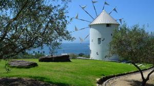 un molino de viento sobre un campo verde en Kokuminshukusha Shodoshima - Vacation STAY 59346v, en Ikeda