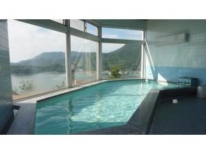 uma grande piscina com vista para a água em Kokuminshukusha Shodoshima - Vacation STAY 59358v em Ikeda