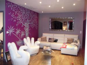 a living room with a white couch and a purple wall at Villa Oyala avec piscine, spacieuse et de qualite in Saint-Pierre-dʼOléron